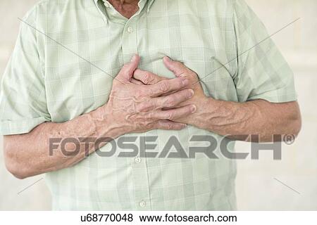 Senior man holding his chest in pain View Large Photo Image Stock Photo - Senior man holding his chest in pain. Fotosearch