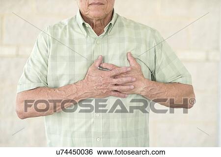 Senior man holding his chest in pain View Large Photo Image Stock Photograph - Senior man holding his chest in pain. Fotosearch