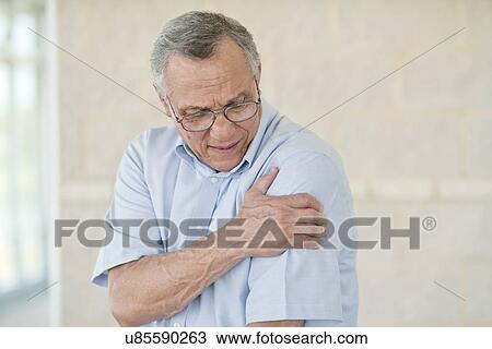 Senior man holding his left arm in pain View Large Photo Image Stock Image - Senior man holding his left arm in pain. Fotosearch