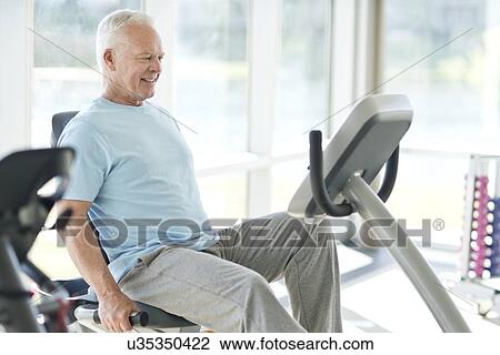 Senior man on static bike View Large Photo Image Stock Image - Senior man on static bike. Fotosearch