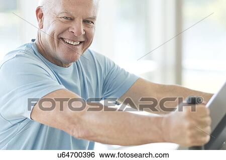 Senior man on static bike View Large Photo Image Stock Photograph - Senior man on static bike. Fotosearch