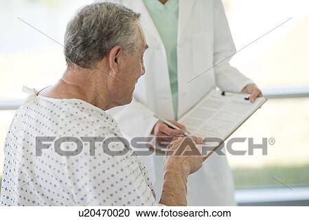 Senior man pointing at medical notes in hospital View Large Photo Image Stock Image - Senior man pointing at medical notes in hospital. Fotosearch