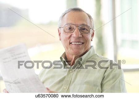 Stock Image - Senior man reading newspaper. Fotosearch