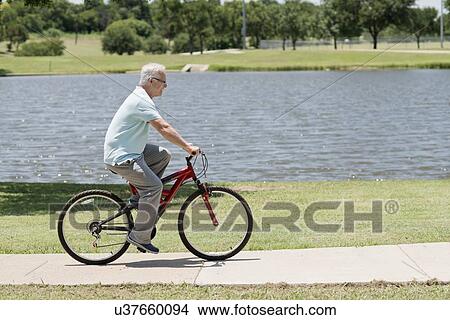 Senior man riding a bicycle View Large Photo Image Picture - Senior man riding a bicycle. Fotosearch