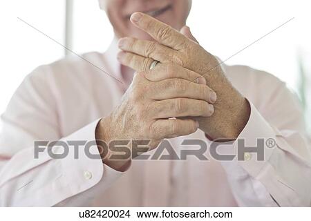 Picture - Senior man rubbing painful hand. Fotosearch