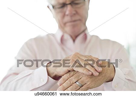 Senior man rubbing painful hand View Large Photo Image Stock Image - Senior man rubbing painful hand. Fotosearch