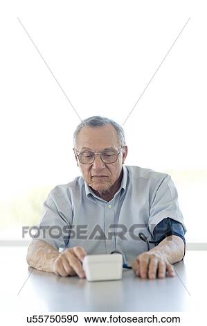 Senior man taking his own blood pressure View Large Photo Image Stock Image - Senior man taking his own blood pressure. Fotosearch
