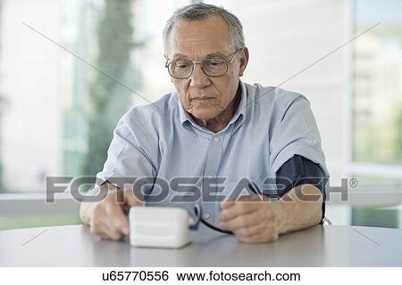 Stock Photograph - Senior man taking his own blood pressure. Fotosearch