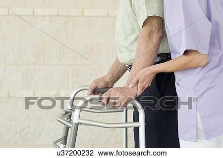 Stock Image - Senior man using walking support frame. Fotosearch