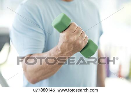 Stock Photography - Senior man using weights. Fotosearch