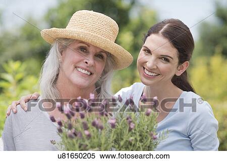 Senior woman and daughter holding pot plant View Large Photo Image Stock Photography - Senior woman and daughter holding pot plant. Fotosearch
