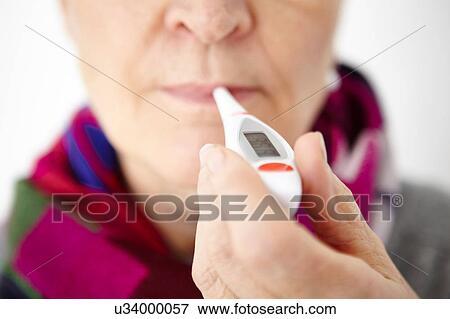 Senior woman holding digital thermometer in mouth, close-up View Large Photo Image Stock Photo - Senior woman holding digital thermometer in mouth, close-up. Fotosearch