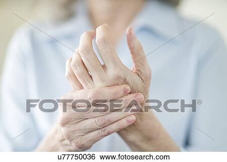 Senior woman holding painful hand View Large Photo Image Stock Photograph - Senior woman holding painful hand. Fotosearch