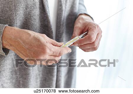 Senior woman holding thermometer, mid section View Large Photo Image Stock Photo - Senior woman holding thermometer, mid section. Fotosearch