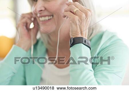 Senior woman listening to music on earphones View Large Photo Image Stock Photo - Senior woman listening to music on earphones. Fotosearch