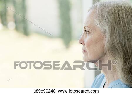 Senior woman looking through window View Large Photo Image Stock Image - Senior woman looking through window. Fotosearch