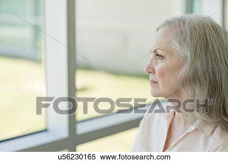 Senior woman looking through window View Large Photo Image Stock Photography - Senior woman looking through window. Fotosearch