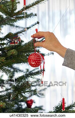 Senior woman putting bauble on christmas tree View Large Photo Image Stock Photography - Senior woman putting bauble on christmas tree. Fotosearch