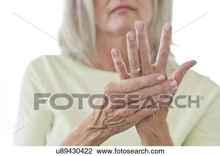 Senior woman rubbing painful hand View Large Photo Image Stock Image - Senior woman rubbing painful hand. Fotosearch