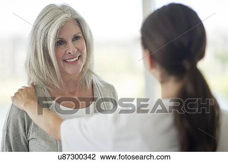 Stock Image - Senior woman talking to care worker. Fotosearch