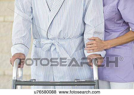 Stock Photo - Senior woman using walking support frame. Fotosearch