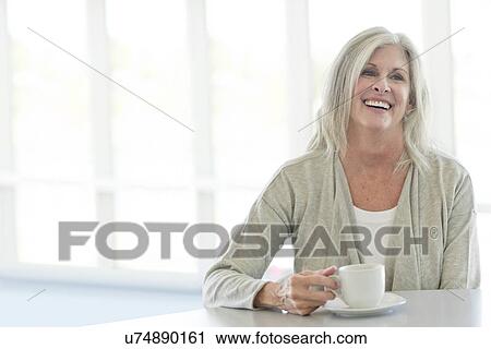 Stock Image - Senior woman with cup of tea. Fotosearch