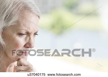 Stock Photography - Senior woman with hand on chin. Fotosearch