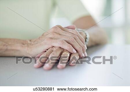 Stock Image - Senior woman with one hand on the other. Fotosearch