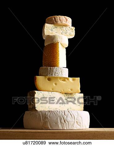 Stock Photo - Stack of selection of cheeses, against black background. Fotosearch