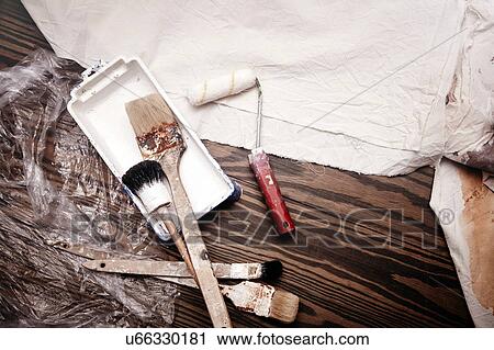 Stock Image - Still life of paint brushes and paint roller, overhead view. Fotosearch