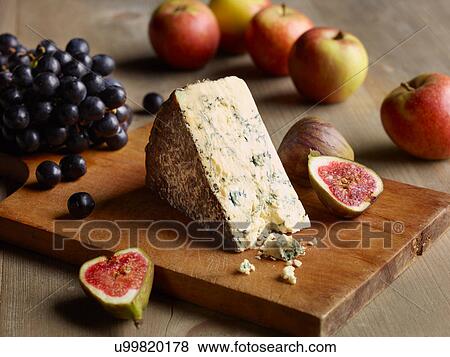 Still life of Stilton on chopping board with figs, apples and grapes View Large Photo Image Stock Photo - Still life of Stilton on chopping board with figs, apples and grapes. Fotosearch