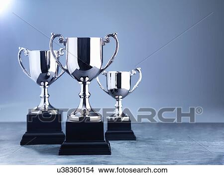 Picture - Still life of three trophies awaiting the winners' presentation. Fotosearch