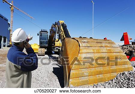 Stock Photo - Surveyor on construction site with bulldozer. Fotosearch
