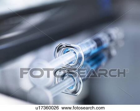 Stock Photograph - Syringe on surgical tray ready for use, close-up. Fotosearch