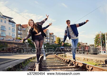 Picture - Three friends balancing on train track, Bristol, UK. Fotosearch