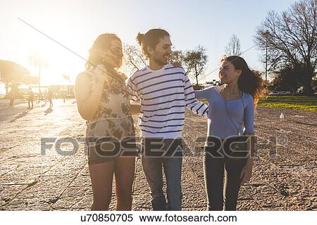 Stock Photography - Three friends, walking on beach, Lisbon, Portugal. Fotosearch