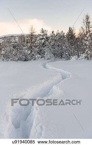 Stock Photography - Trails through deep snow at Lake Reynisvatn, Iceland. Fotosearch