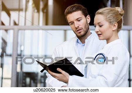 Two doctors looking at diary View Large Photo Image Stock Photography - Two doctors looking at diary. Fotosearch