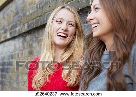 Stock Photo - Two female friends, outdoors, laughing. Fotosearch