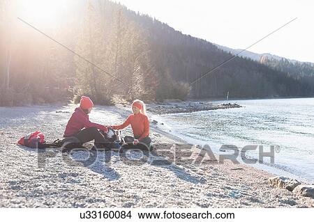 Two female hikers taking a break on lakeside in Bavarian Alps View Large Photo Image Picture - Two female hikers taking a break on lakeside in Bavarian Alps. Fotosearch