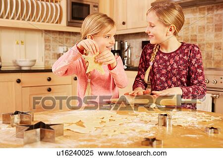 Two girls baking star shape pastry at kitchen table View Large Photo Image Stock Photography - Two girls baking star shape pastry at kitchen table. Fotosearch