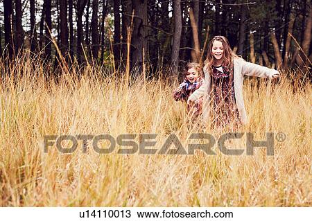 Two young girls running through meadow, hand in hand View Large Photo Image Stock Image - Two young girls running through meadow, hand in hand. Fotosearch