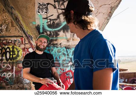 Two young men chatting in mine ruins View Large Photo Image Stock Photograph - Two young men chatting in mine ruins. Fotosearch