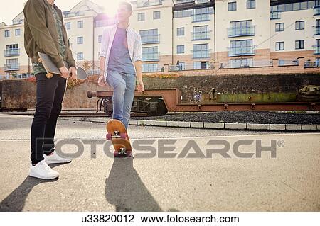 Two young men skateboarding in urban area, Bristol, UK View Large Photo Image Stock Image - Two young men skateboarding in urban area, Bristol, UK. Fotosearch