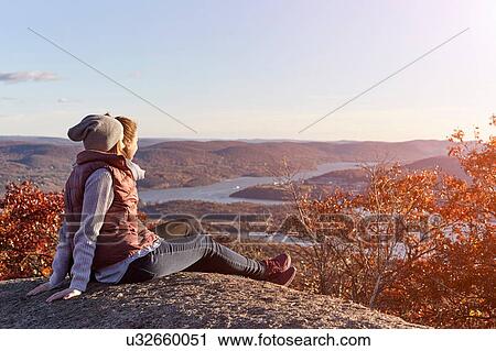Stock Image - Two young women looking out over lake and hills, New York State, USA. Fotosearch