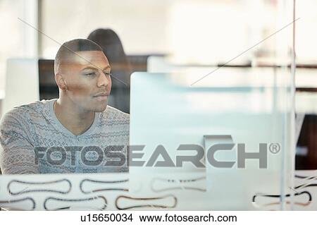 University student working at computer behind glass partition View Large Photo Image Picture - University student working at computer behind glass partition. Fotosearch