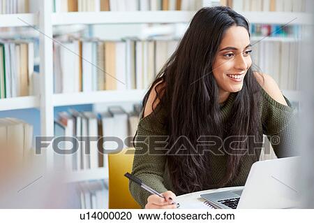 Stock Image - University student working in library. Fotosearch