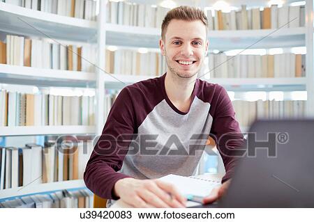 Stock Image - University student working in library. Fotosearch