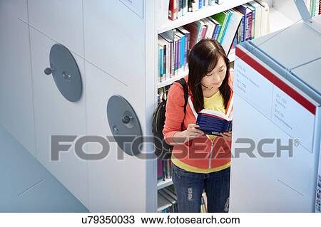 Stock Image - University student working in library. Fotosearch
