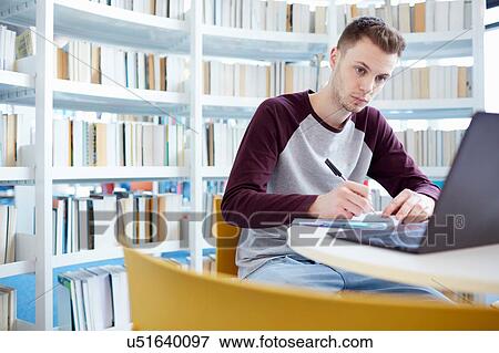 Stock Photo - University student working in library. Fotosearch